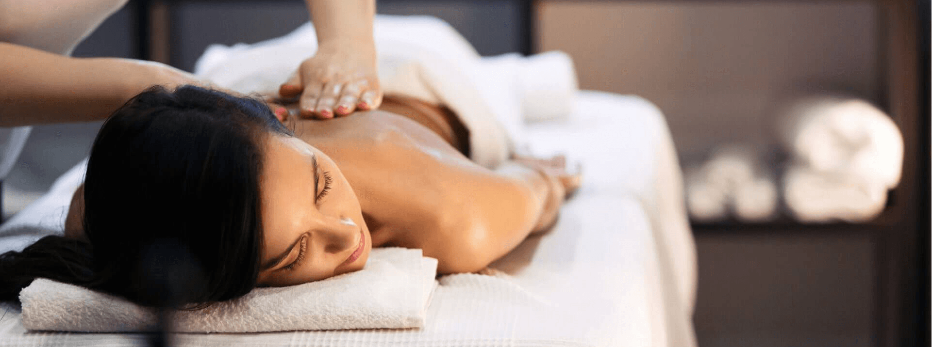 A person receiving a massage while lying on a treatment table.