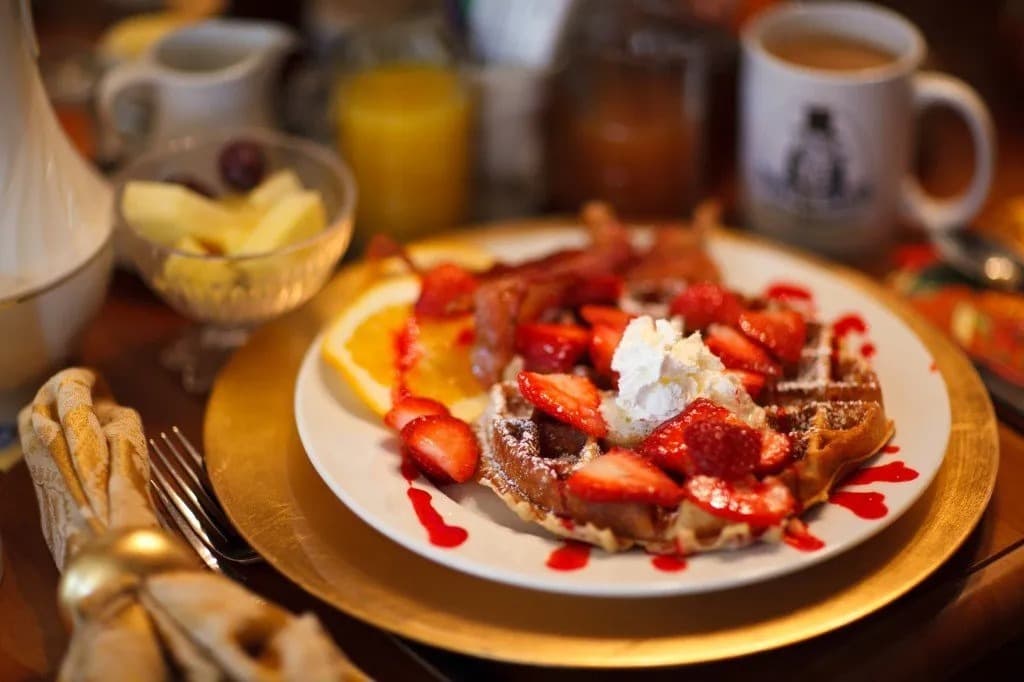 waffle covered with sliced strawberries and whipped cream waffle covered with sliced strawberries and whipped cream